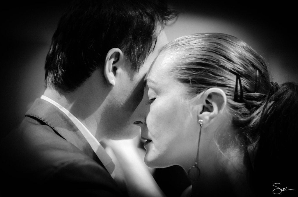 Close-up of a man and woman embracing in a dance, their foreheads touching, conveying intimacy and connection.